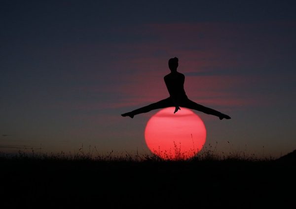 Woman bouncing over the sun