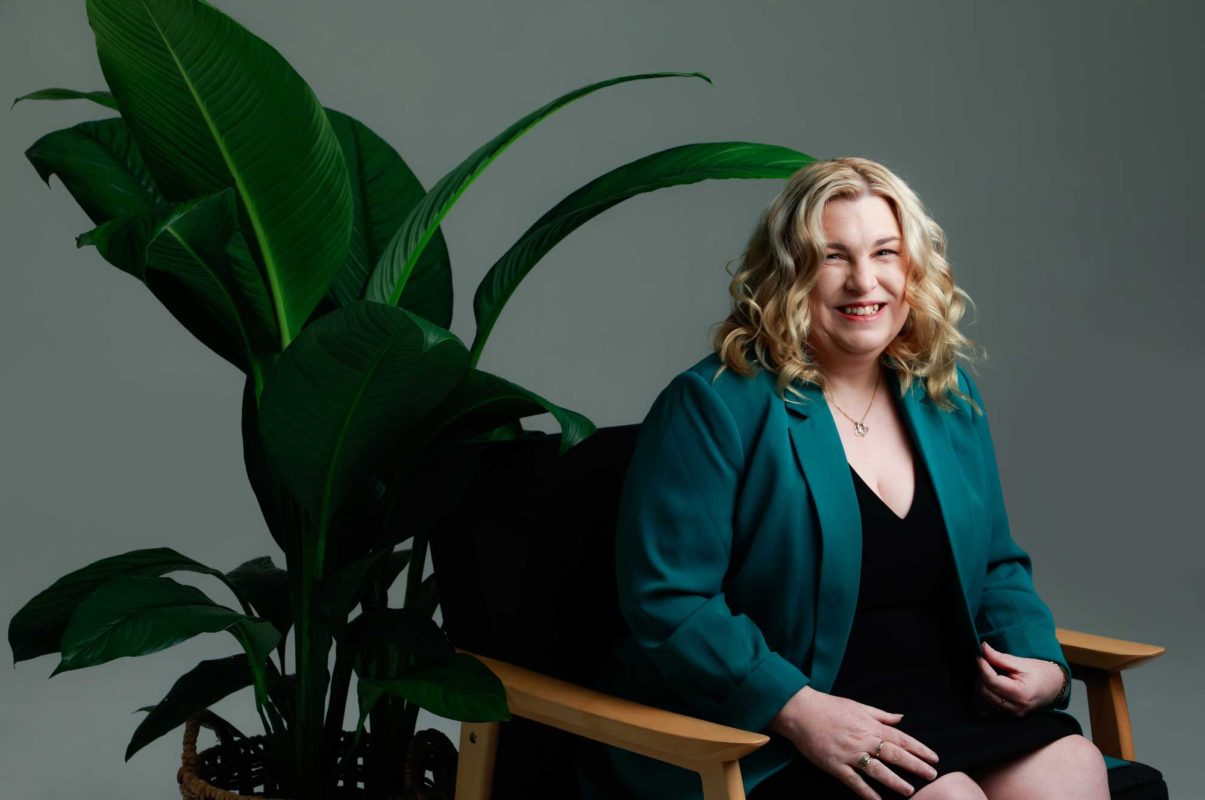 fiona demark smiling with a plant in the background
