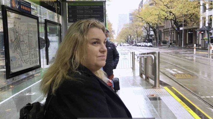 fiona demark seated at tram stop reflecting on her career in the public service