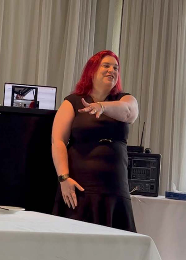 fiona demark keynote speaker gesturing with her hands and smiling during a keynote speech