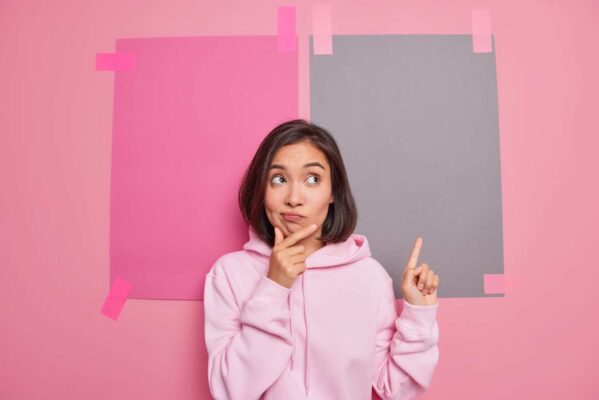 woman comparing two blank coloured pieces of paper