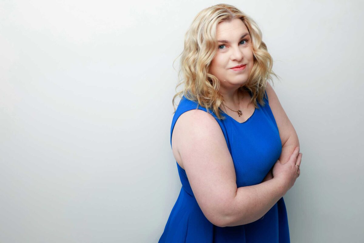 fiona demark wearing a blue dress looking at the camera